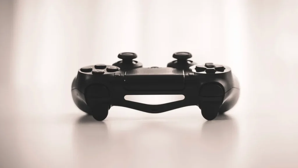 Close-up of a black game controller on a light surface, showing a clean, minimalist profile.