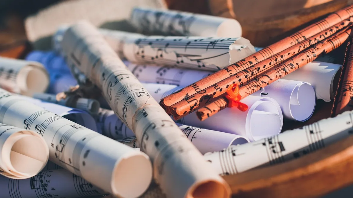 Rolled-up sheets of sheet music, symbolizing musical scores and creative composition.