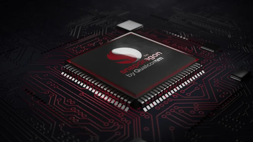 A Snapdragon by Qualcomm processor chip set on a dark circuit board with red traces.
