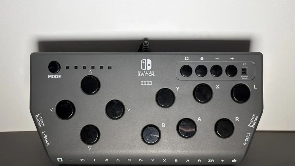 Grey Hori leverless controller for Nintendo Switch, featuring a button-heavy fighting layout on a clean grey surface.