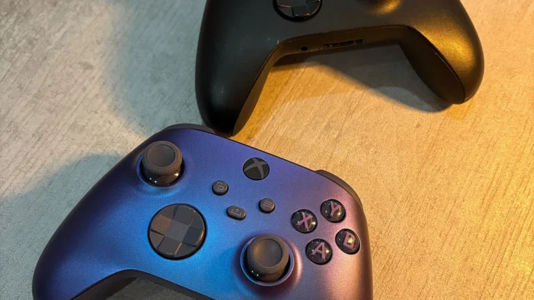 Shimmering blue-purple and black Xbox controllers on a wooden surface, showcasing gaming hardware.