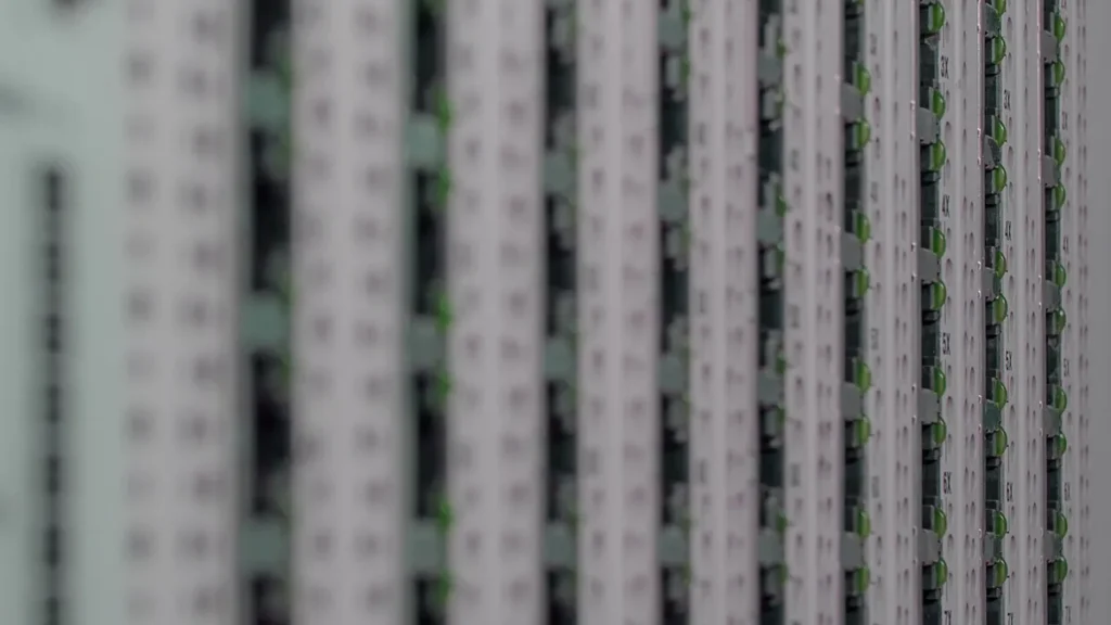 Close-up of vertical server racks with green status lights and column labels like 3X and 4X on the right side.