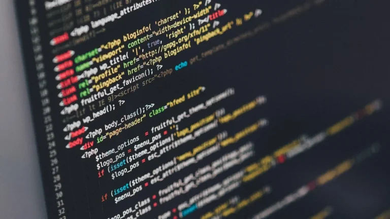 Close-up of colorful programming code on a dark screen, showing lines of syntax-highlighted web script.