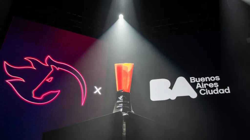 A red trophy is spotlighted on stage between a neon red horse logo and the Buenos Aires Ciudad logo.