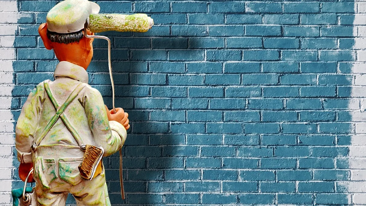 Clay figure painter applying blue paint to a brick wall, symbolizing visual updates and graphical polish.