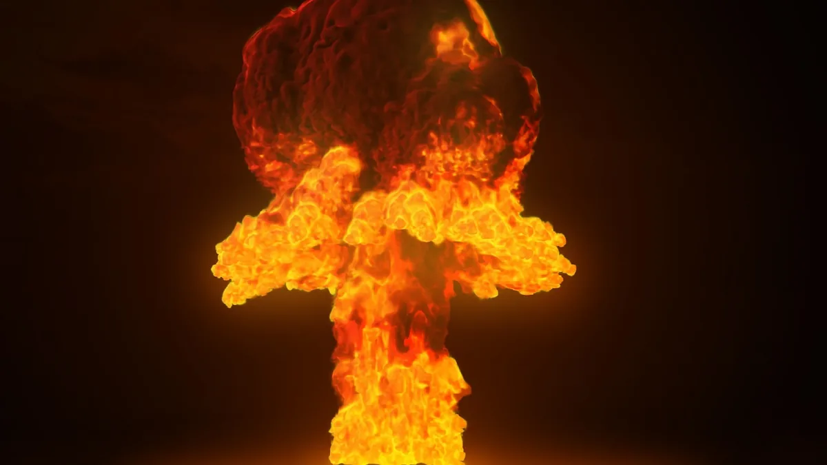 A dramatic orange and red nuclear mushroom cloud explosion glowing against a dark background.