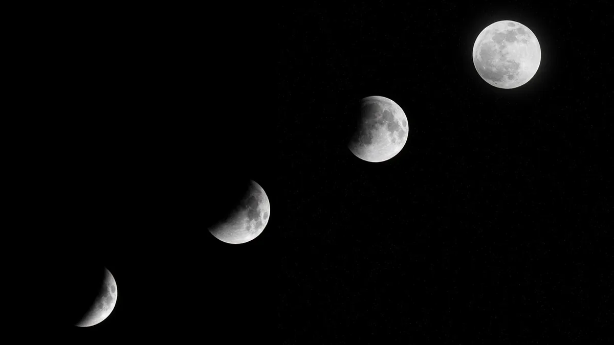 A sequence of four moon phases progressing diagonally across a dark, starry black sky.
