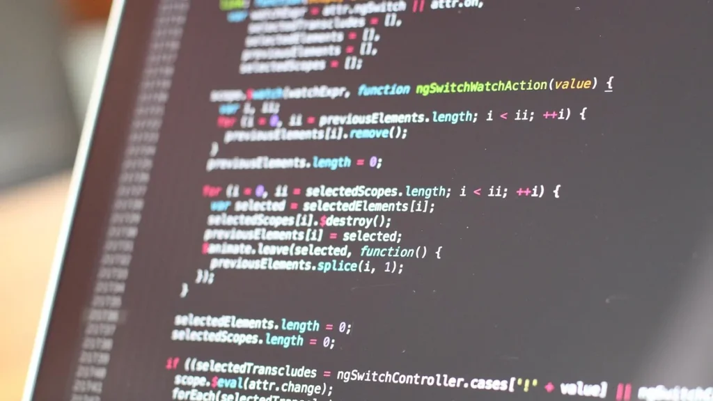Close-up of colorful JavaScript code on a dark laptop screen.