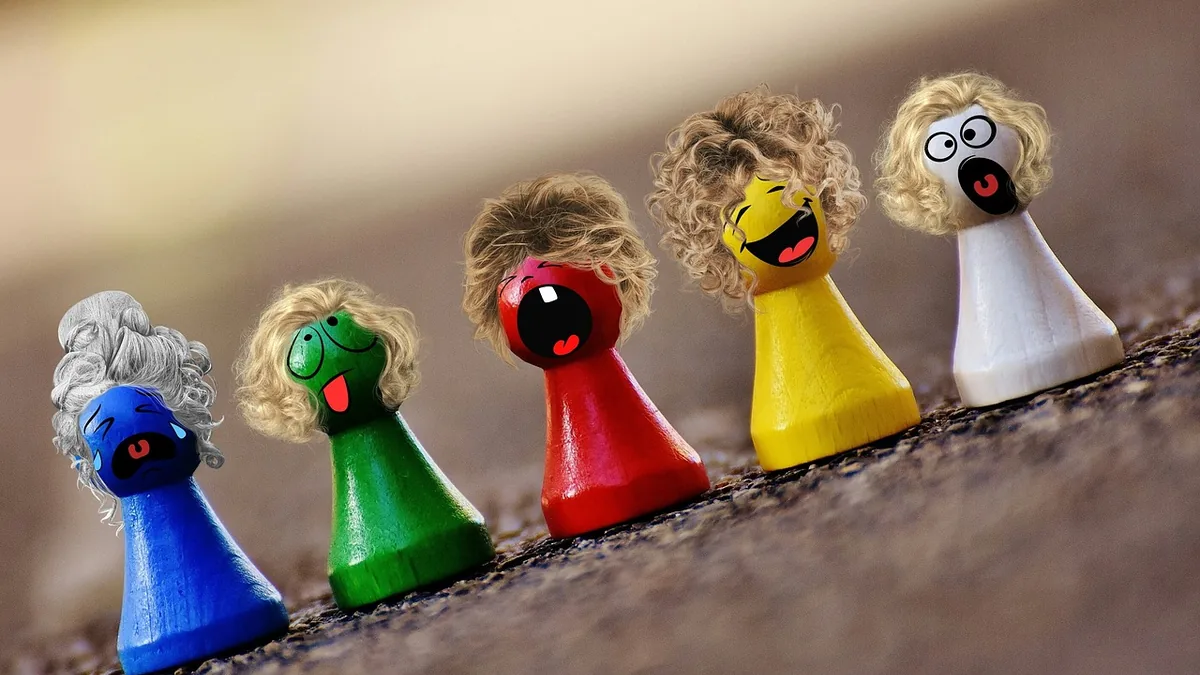 Five colorful wooden pawn figures wearing wigs and showing exaggerated cartoon facial expressions of sadness, silliness,
