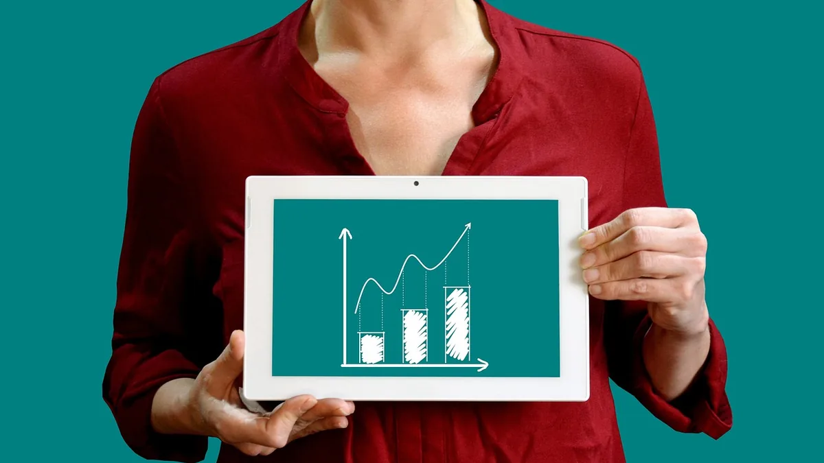 A person in a red shirt holds a tablet displaying a white growth chart on a teal background.
