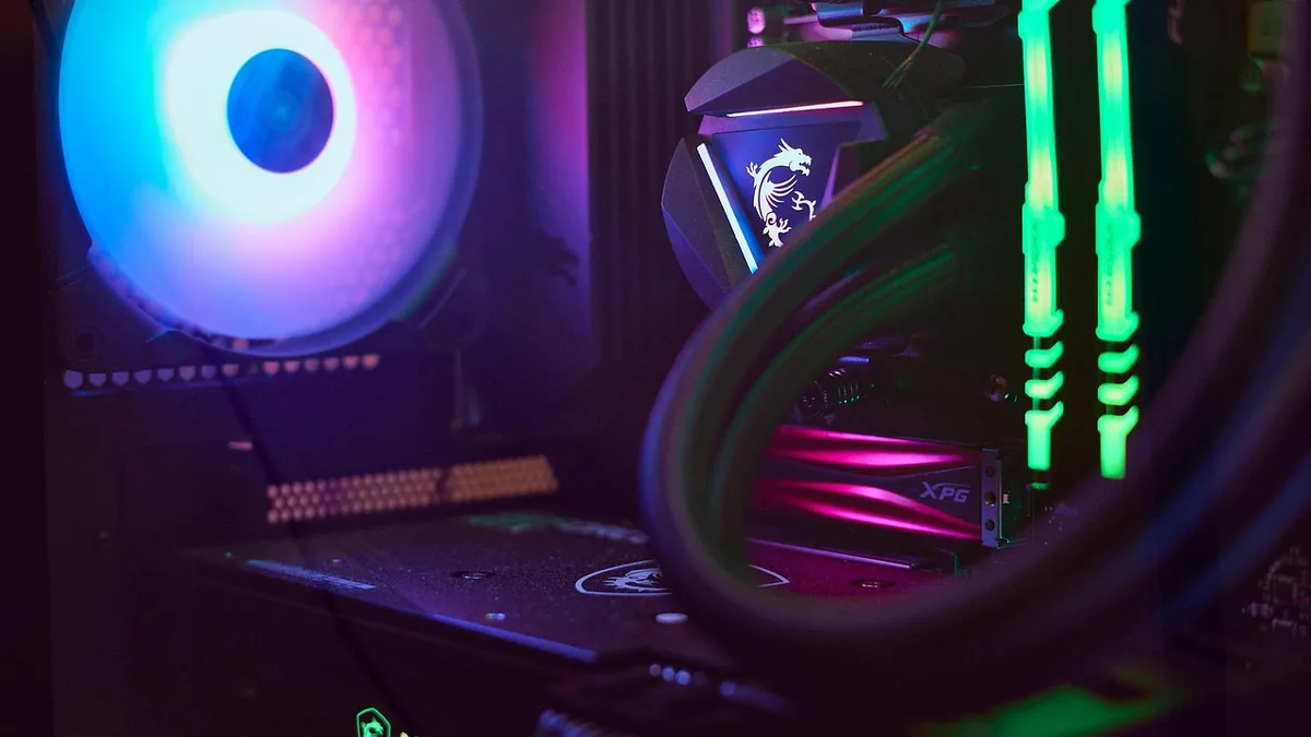 A close-up of a vibrant RGB-lit gaming PC interior showing cooling fans, RAM, and the MSI dragon logo.