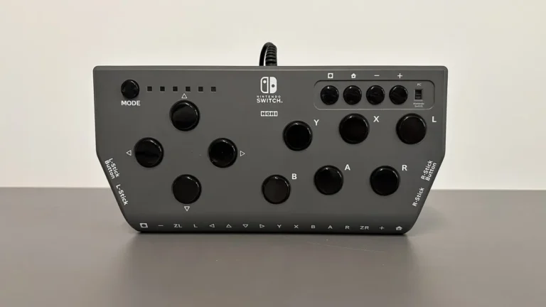 Grey Hori Nintendo Switch controller with multiple black buttons displayed on a grey surface.