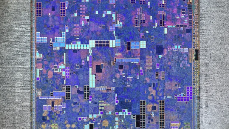 Colorful close-up of a silicon processor die with intricate blue, purple, and gold microcircuitry patterns.