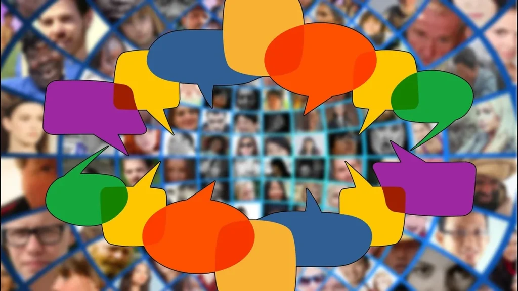 Colorful speech bubbles form a circle over a grid of blurry faces, symbolizing collective community voices and discussion.