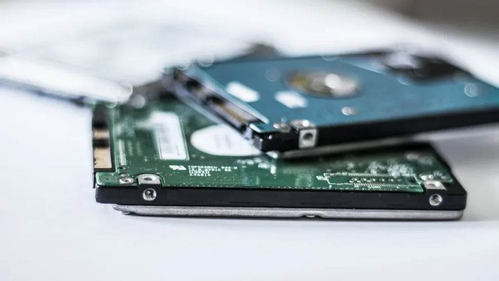 Close-up of stacked green and blue storage drives on a white surface.