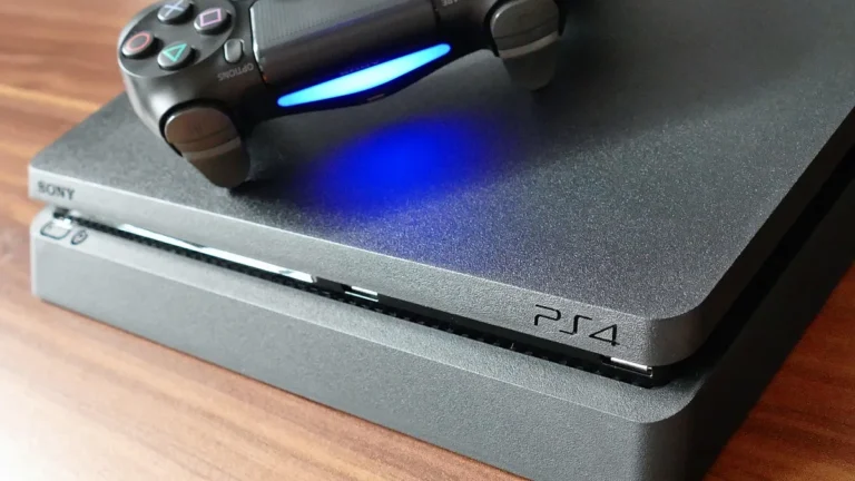 A black Sony PlayStation 4 console with a DualShock 4 controller on top, glowing blue light bar.