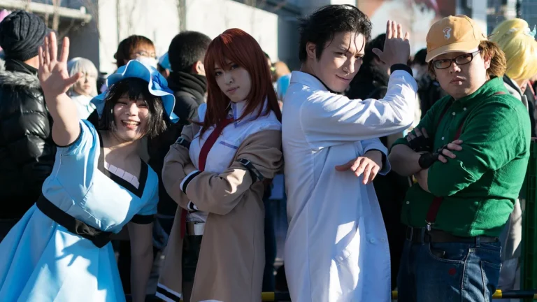 Cosplayers dressed as Steins;Gate characters Okabe, Kurisu, Mayuri, and Daru pose together outdoors.