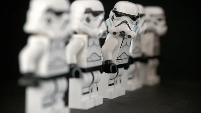 Lego Stormtrooper minifigures lined up in a row, with the central figure in sharp focus against a dark background.