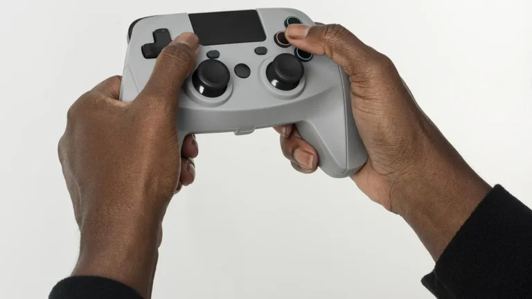 Close-up of a person's hands holding a grey video game controller against a clean white background.