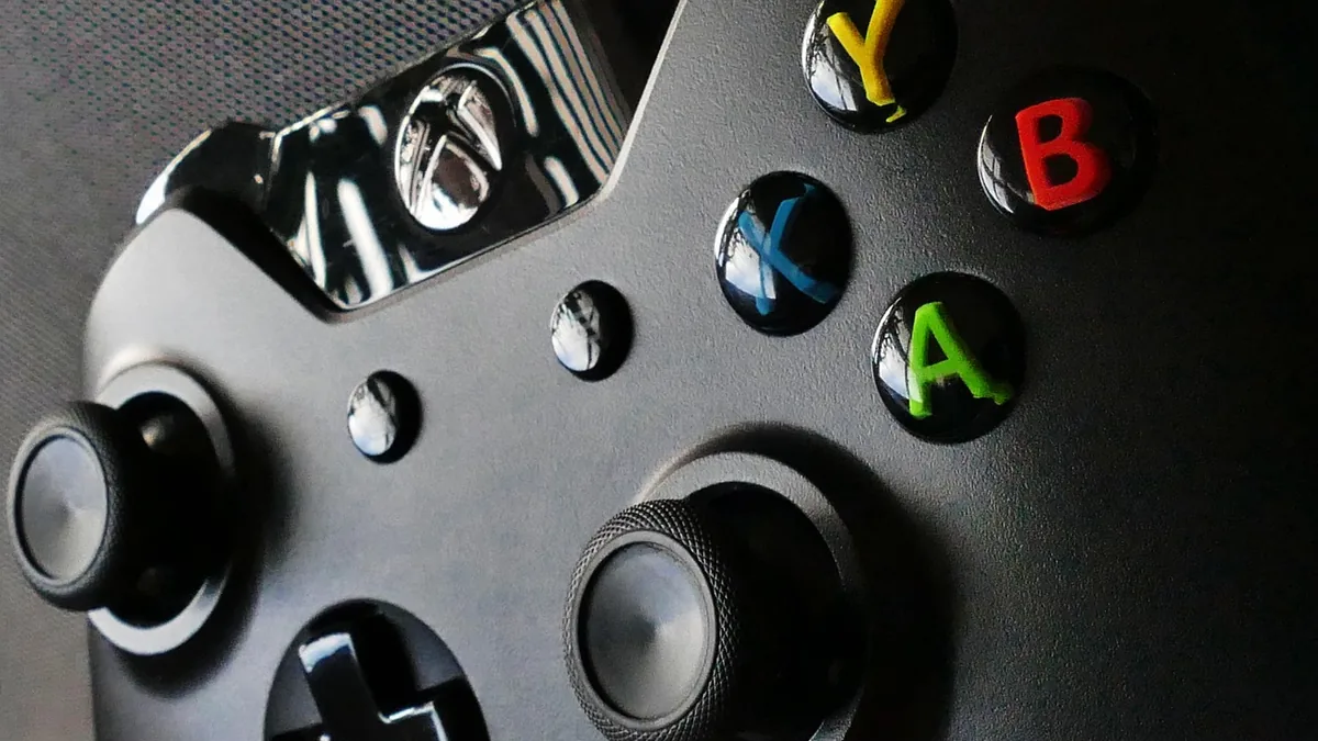 Close-up of Xbox controller buttons with stickers showing A, B, X, Y, and directional pad